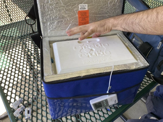 Moderna’s COVID-19 vaccine vials are stored in a portable cooler called a Crēdo Cube. Alongside it are three empty vials.