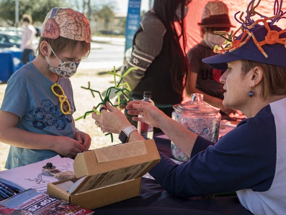 Jonathan Murphy listens to Helena Morrison, PhD, an associate professor at the University of Arizona College of Nursing, teach him about brain cells during the recent Family SciFest at Children's Museum Tucson. Murphy got to build brain cells out of pipe cleaners and was given a brain cell coloring sheet and stickers.