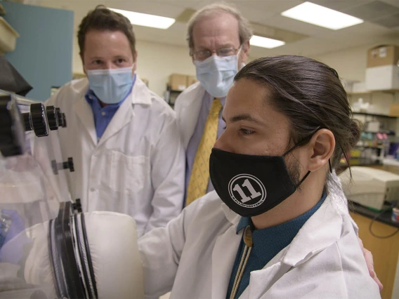 Doctoral student Corbin Jensen (right) alongside mentors Drs. Noel Warfel and Andrew Kraft. Each scholar is expected to conduct original research under the guidance of their chosen mentor-pair, and to participate in clinical cases with their chosen physician mentor.