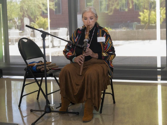 Mary Redhouse plays the American flute inside the Health Science Innovation Building during a reception after the groundbreaking ceremony for the Andrew Weil Center for Integrative Medicine on the University of Arizona Health Sciences campus in Tucson.