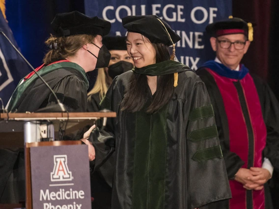 Laura Mercer, MD, MPH, MBA, (left) director, OB/GYN clerkship and director, intersessions course, congratulates Pristine Mei, MD, after she was hooded at the College of Medicine – Phoenix class of 2022 commencement ceremony.