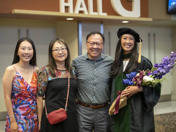 College of Medicine – Phoenix class of 2022 graduate Belle Lin, MD, (right) poses for a photo with her family after her commencement ceremony. Dr. Lin’s family, from left, are sister, Danni Lin, mother, Alice Lin, and father, Jerry Lin.