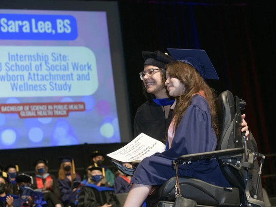 (From left) Gabriela Valdez, PhD, director of global education and global health programs, poses for a photograph with Bachelor of Science graduate Sara Lee as she crosses the stage at Centennial Hall during the 2022 Mel and Enid Zuckerman College of Public Health spring convocation.