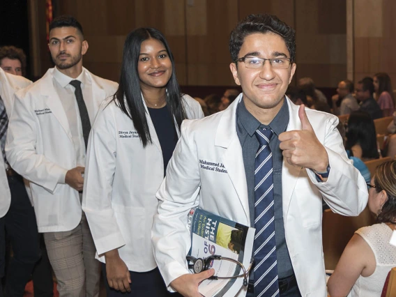 (From right) Muhammed Amir Jaafar, Divya Jeyasingh and Michael Mazarei leave Symphony Hall in a procession after the UArizona College of Medicine – Phoenix Class of 2026 white coat ceremony.