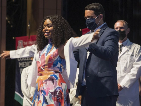 Bre’annca Charell Sanders is presented with her white coat by Francisco Lucio, JD, associate dean of equity, diversity and inclusion for the UArizona College of Medicine – Phoenix.