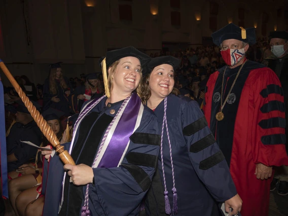 Christine Platt, who earned her Doctor of Philosophy in Nursing and Doctor of Nursing Practice, and Sally Martens, who earned her Doctor of Philosophy in Nursing, pause for a photo as they walk into Centennial Hall during the College of Nursing 2022 summer convocation.