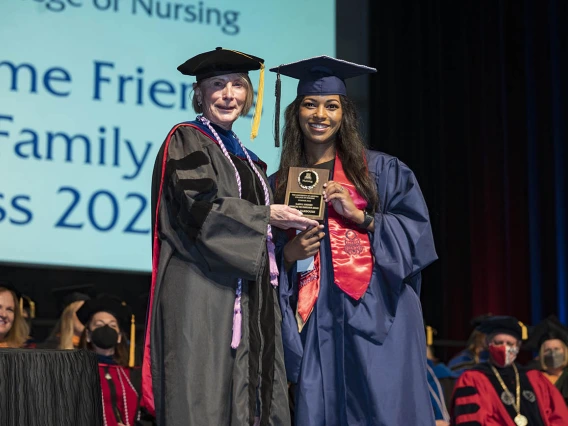 College of Nursing interim Dean Kathleen Insel, PhD, presents the Gladys E. Sorensen Award for Academic Excellence to Leila Darbouze, Master of Science in Nursing Entry to the Profession student, at the college’s 2022 summer commencement.