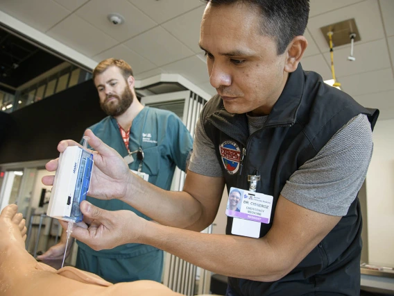 ASTEC’s SimDeck is a two-story soundstage and training environment with multiple reconfigurable rooms where health care providers, such as this emergency medicine resident, can practice medical procedures in simulated environments.