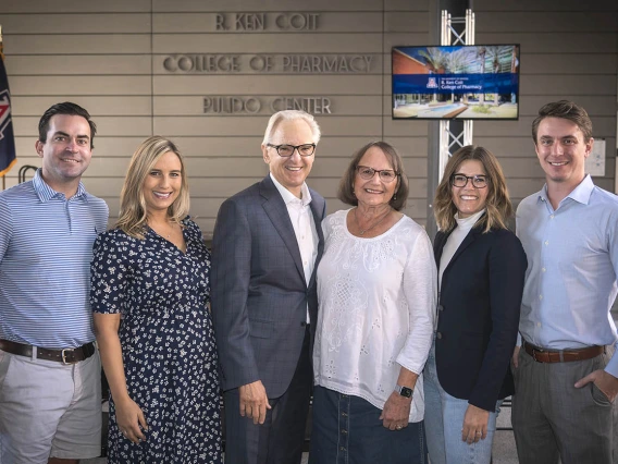 From left, Shyler Ackley, Lauryn Coit Ackley, R. Ken Coit, Donna Coit, Shannon Coit and Colin Michel pose for a family photo under the newly-unveiled signage for the R. Ken Coit College of Pharmacy. 