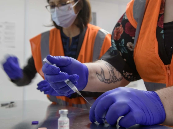 UArizona Campus Health registered pharmacist Elizabeth Preble (left) and fourth-year College of Pharmacy student Annie Hiller prepare to mix the Pfizer vaccine with saline.