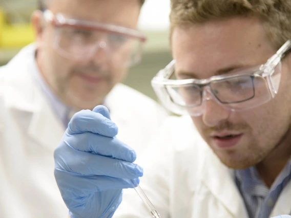 Chris Foley, PhD, right, is a postdoctoral researcher in the Hulme Lab, which is devoted to finding ways to nip Alzheimer’s disease in the bud by targeting an enzyme crucial to its development. Chris Hulme, PhD, is pictured in the background.