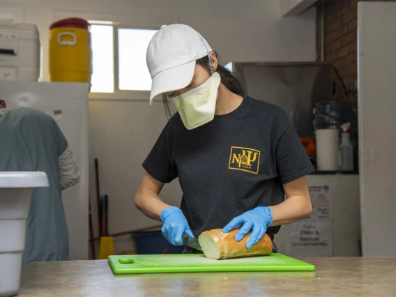 Koustubh Kandapalli slices bread to prepare meals to distribute to Tucson’s homeless population. The medical student is volunteering to serve the vulnerable population during the COVID-19 pandemic.