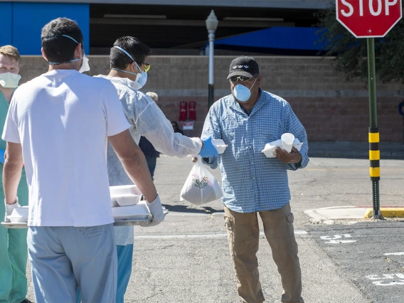 Students in the College of Medicine – Tucson distributed food, water and medical care to the homeless population in downtown Tucson during the pandemic. Pictured here in April near the Z Mansion, a food distribution site for the homeless population several times a week.