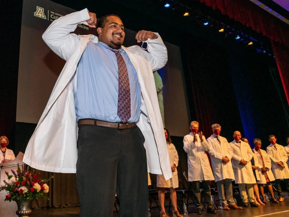 D'Andre Gomez gives a flex to the crowd after being presented his white coat by Dr. Puneet Schroff. 