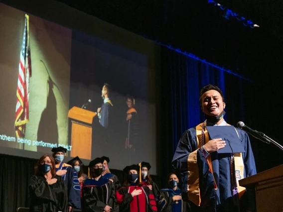 Kevin Vidal sings the National Anthem during the College of Nursing’s August commencement at Centennial Hall.