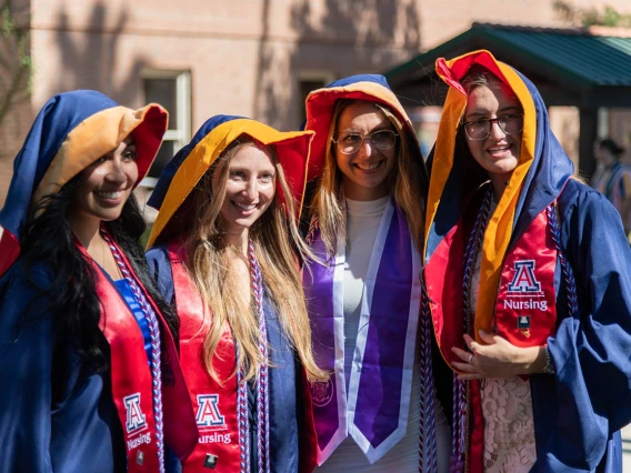 Freshly hooded graduates from the August commencement pose for a photo.