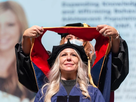 Amanda Keenhold, who received a Doctor of Nursing Practice, is hooded during the College of Nursing fall convocation at Centennial Hall.