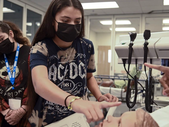 ACES camper Yazmin Pino moves her finger left to right to see if the patient simulator’s eyes will follow her movement.