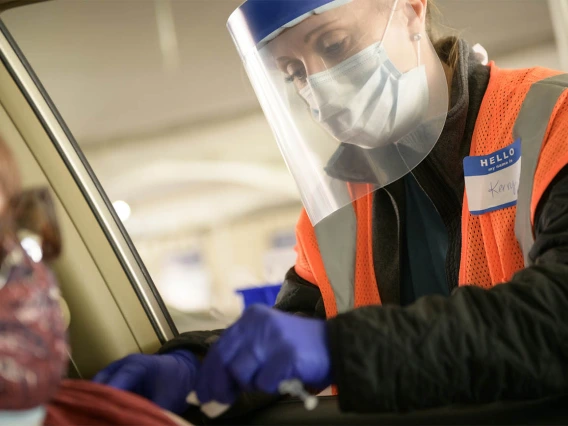 Kerry Johnson uses an alcohol swab to disinfect a driver’s arm at the site of injection.