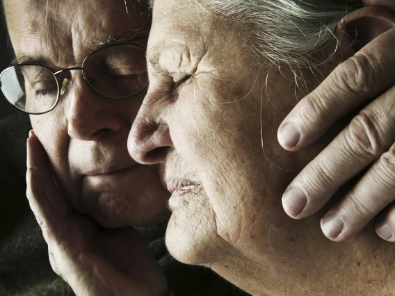 A middle-aged son comforting his aging mother.