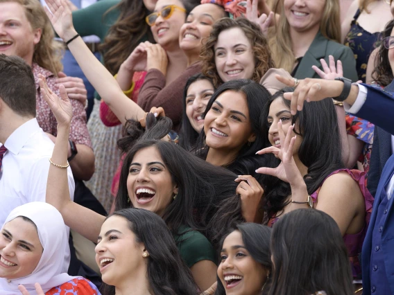 Dozens of fourth-year medical students from the University of Arizona College of Medicine – Tucson wave, smile and show the hand sign for “Wildcats.” 