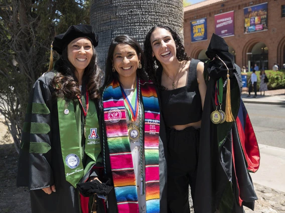 Brianna Dolana, MD, Naiby Rodriguez Zuniga, MD, and Cara Sasha Popeski, MD, pause to take a photo before their College of Medicine – Tucson class of 2022 convocation at Centennial Hall.