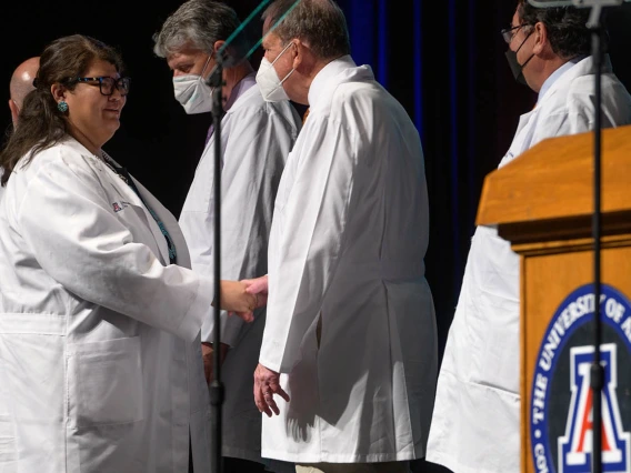 Nicole Bratsch is congratulated by Michael D. Dake, MD, senior vice president for UArizona Health Sciences, after receiving her white coat at the UArizona College of Medicine – Tucson Class of 2026 white coat ceremony.