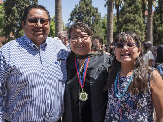 Desiree Smiley, PharmD, poses for a photo with her family after the R. Ken Coit College of Pharmacy 2022 spring convocation at Centennial Hall.