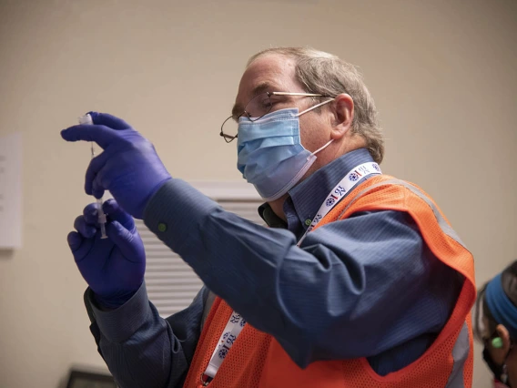 College of Pharmacy professor David Nix, PharmD, prepares the Pfizer COVID-19 vaccine for the Pima County drive-through Point of Distribution (POD) at the University of Arizona.