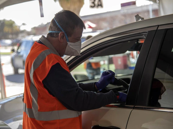 College of Pharmacy professor Michael Katz, PharmD, prepares to administer a COVID-19 vaccine to a patient at the Pima County drive-through POD at the University of Arizona.