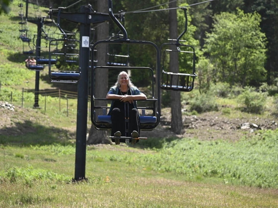 Kathleen Rodgers, PhD, professor of Pharmacology at the College of Medicine – Tucson, takes in the scenery and cooler mountain temperatures while riding the ski lift at Mt. Lemmon during a trip with students from the URBRAIN program.