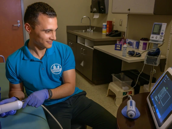 Edgar A. Villavicencio does a FibroScan test on a Nosotros Comprometidos a Su Salud (Committed to Your Health) study participant.