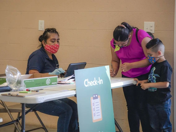 Alma Ramirez, a health educator with the College of Public Health, greets people at the community center in Aguila, Arizona, where UArizona Health Sciences provided free COVID-19 vaccinations. 