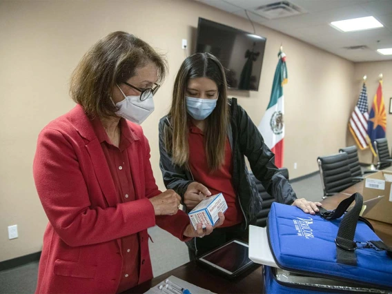 Cecilia Rosales, MD, and Sheila Soto, MPH, director and manager of the Tucson mobile health unit at the UArizona Mel and Enid Zuckerman College of Public Health, review packaging for the COVID-19 vaccines to be administered at a clinic hosted April 23 at the Mexican Consulate in Douglas, Ariz. Initially for farmworkers crossing over from Mexico starting at 3 a.m., the clinic was open to the public from 7 to 11 a.m.