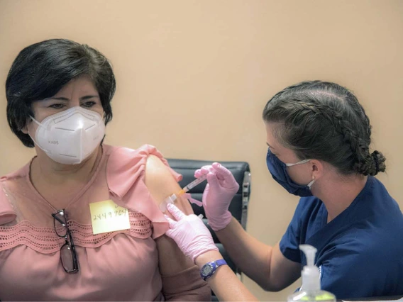 College of Nursing student Kathleen Gies vaccinates a patient at a MOVE UP COVID-19 clinic held by UArizona Health Sciences in Douglas, Ariz., in partnership with the Cochise County Health Department and Consulate of Mexico.