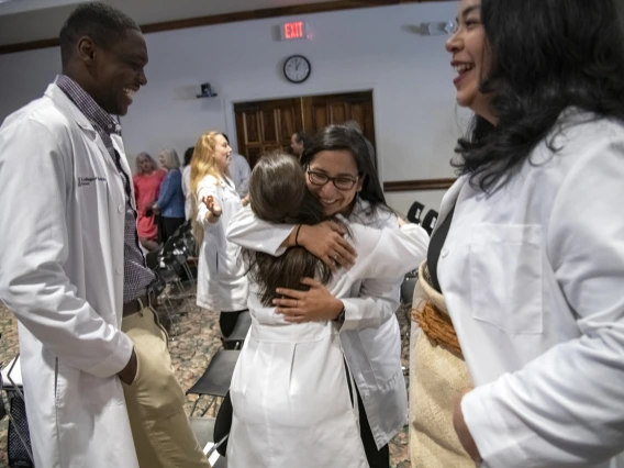 The first group of recipients of the Primary Care Physician scholarship program celebrated their awards at a reception in Tucson. These students – eight in Phoenix and 21 in Tucson, have committed to practicing a primary care profession in an underserved urban or rural community in Arizona. Here, Caylan Moore, left, and Kaloni Philipp, right, watch as Naiby Rodriguez, center, hugs China Rae Newman after the PCP Scholarship reception in Tucson, Ariz.