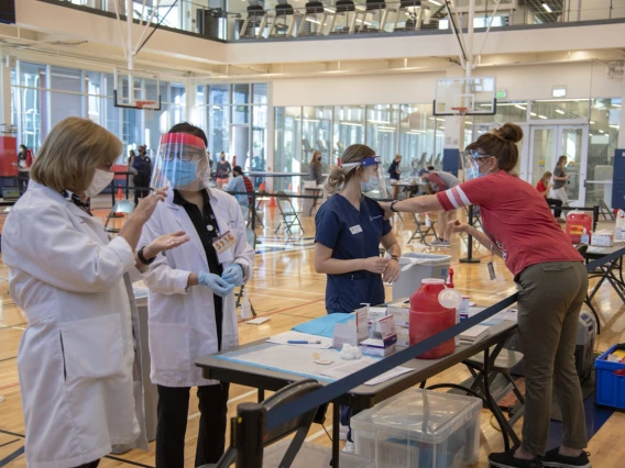 Lisa Davis, PharmD, professor of pharmacy practice and science (left), speaks to PharmD student Lisa Le as College of Nursing student Genevieve Veneziale gets advice from Campus Health nurse Karen Schwartz, RN (right).