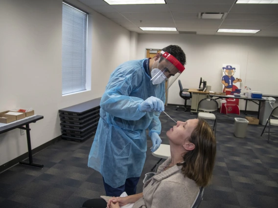 Jeffery Hanna administers a COVID-19 PCR test to UArizona faculty member. Hanna is affiliated with the Mel and Enid Zuckerman College of Public Health in Phoenix. COVID-19 PCR testing was offered at both the Tucson and Phoenix campuses in 2020. A real-time polymerase chain reaction (RT-PCR) test is a molecular diagnostic testing technique that detects the genetic material from the virus. The samples can be collected in a variety of ways, including nasopharyngeal swab and saline gargle.