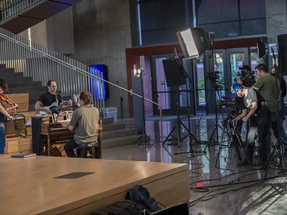 At the base of The Forum, musicians and a film crew prepare for a live-streamed music event.