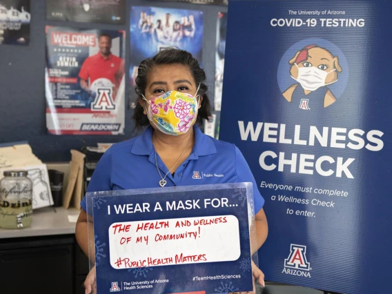 Alma Ramirez, a health educator  from the Mel and Enid Zuckerman College of Public Health’s Phoenix campus, holds a sign that reads, “I wear a mask for the health and wellness of my community.”