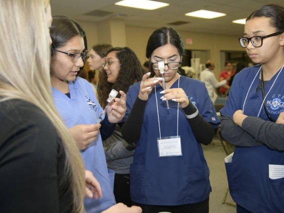 High school students learning about career options in health care visit the nursing booth.