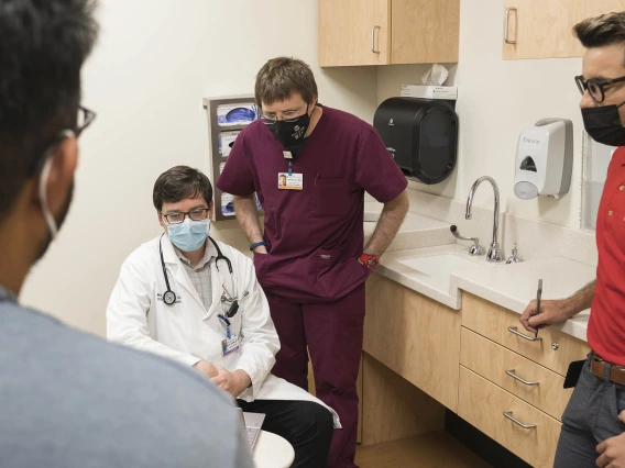 (From right) Cesar Egurrola, lead clinical coordinator and case manager; Larry York, PharmD, BCIDP, BCPS, AAHIVP, clinical pharmacist, infectious diseases and HIV/AIDS; and Matthew Adams, DO, speak with a visitor at the Petersen Clinic. 