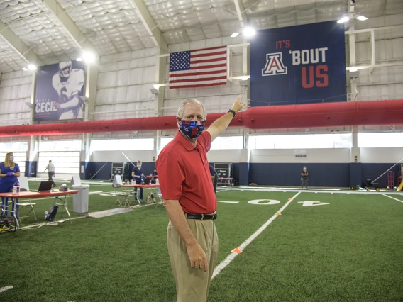 University of Arizona President Robert Robbins, MD, points to a University of Arizona sign as he waits to take the COVID-19 antibody test on April 30, 2020.