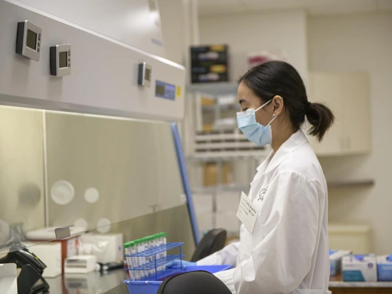 Lab technician Cindy Bujanda places a set of antigen sample tubes under the hood in the testing laboratory. 