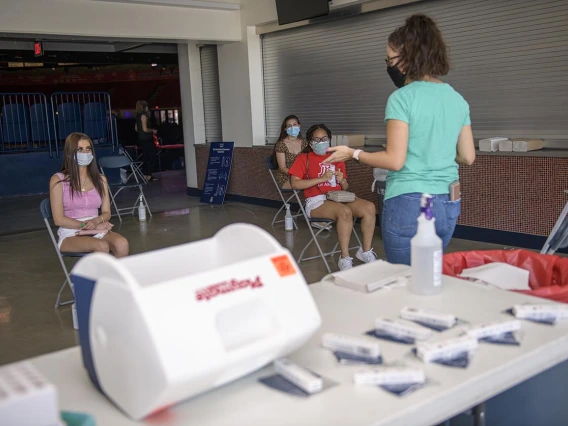 University of Arizona students get tested for COVID-19 by taking a self-administered antigen test at McKale Center in Tucson. 