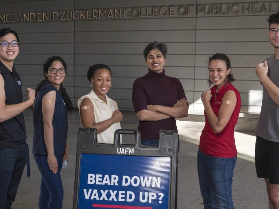 Members of the Alliance for Vaccine Literacy group started by Purnima Madhivanan, PhD, MBBS, MPH,  (center arms crossed) flex their muscles in supporting the UArizona Health Sciences community in effectively talking with vaccine hesitant friends and family. (From left) Students Wesley Chiu, Himanashi Kapoor, Dametreea Carr McCuin, Dr. Madhivanan, Maiya Block, MPH, and Riley Sena.