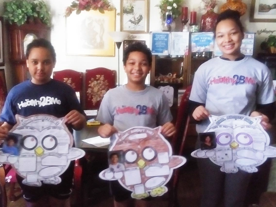 Siblings from the White family show off one of their camp projects.