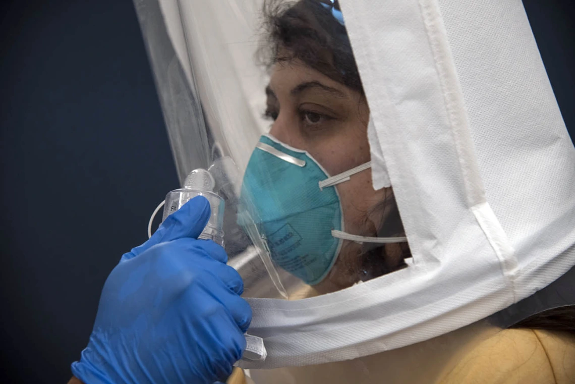 Bitters are sprayed directly toward College of Medicine – Tucson second-year student Sanga Shir, who is decked out in a hooded mask and N95 respirator.