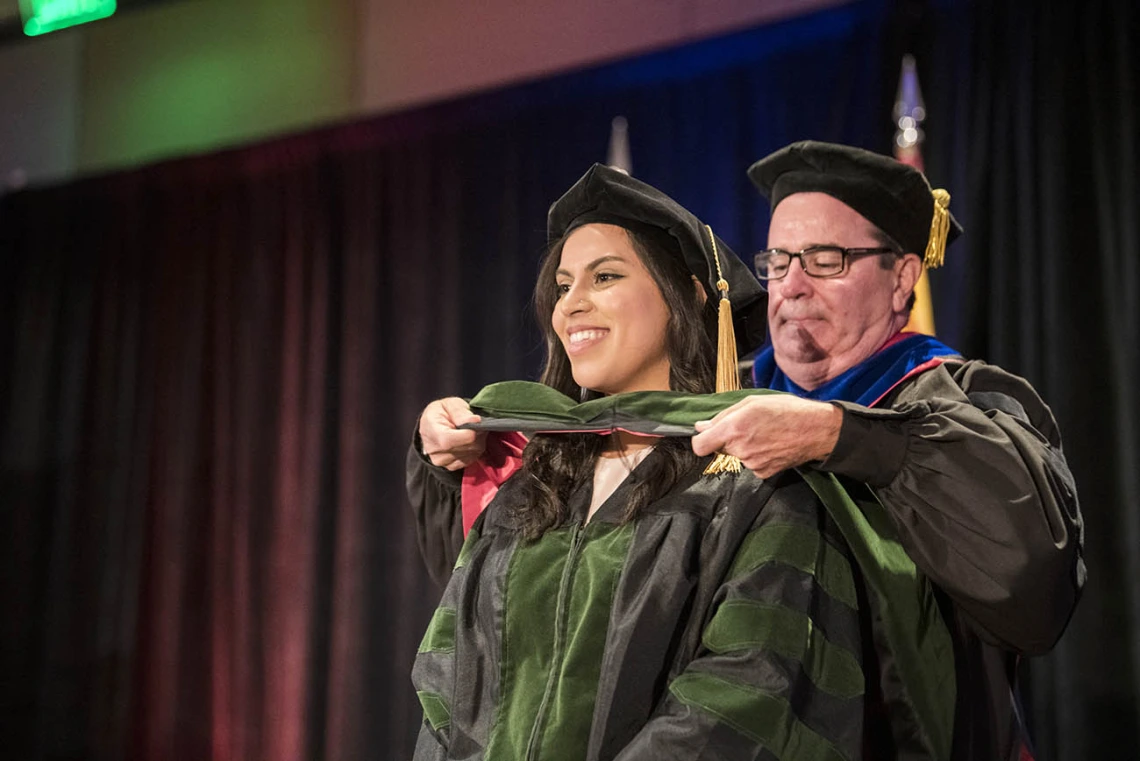 Sokena Batool Zaidi, MD, is hooded by Paul Standley, PhD, associate dean, curricular affairs and program evaluation, during the College of Medicine – Phoenix class of 2022 commencement ceremony.