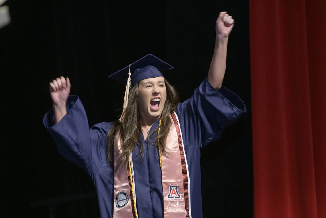 Katelyn Maple cheers as she walks on stage to receive her Bachelor of Science in Public Health during the 2022 Mel and Enid Zuckerman College of Public Health spring convocation.